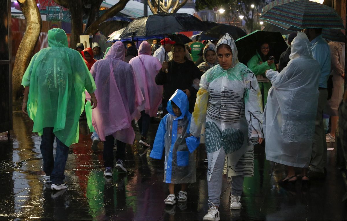 CIUDAD DE MÉXICO, 28JUNIO2026.- Continúan las fuertes lluvias en la capital del país. En el Centro Histórico, personas que transitan por la zona o salen del FIFA Fan Fest buscan resguardarse de la lluvia y se cubren con lo que encuentran para protegerse de las precipitaciones. FOTO: CAMILA AYALA BENABIB / CUARTOSCURO.COM